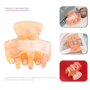 Detail view of mini marble textured acetate hair claw clip with a secure metal spring