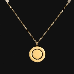 Detail of a rotating double-layer geometric pendant necklace with brushed gold finish