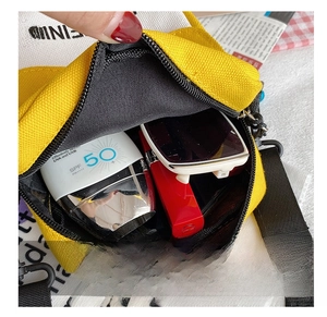 Detail view of the yellow canvas crossbody bag interior showing spacious storage for essentials