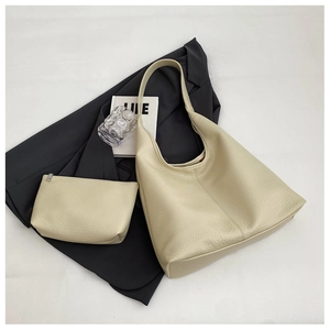 Detail of cream large tote bag and matching pouch with premium lychee grain leather texture