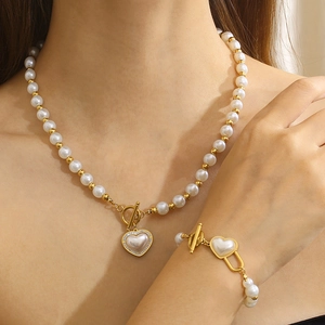 Elegant stainless steel pearl jewelry set with heart pendant and gold toggle clasp