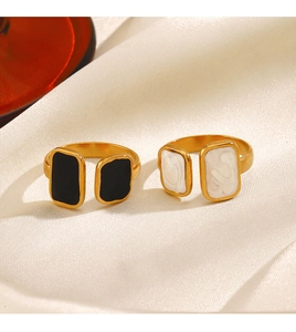 Close-up of vintage golden square enamel rings on elegant white silk background