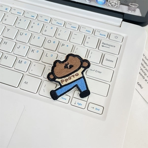 Macro detail of cartoon cookie embroidery patch with PHOTO text on a laptop keyboard