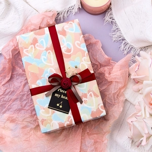Romantic heart pattern gift wrapping paper with red ribbon and elegant accessories