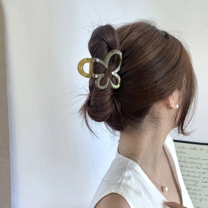 Close-up of a butterfly hair claw clip in amber acetate worn on a model's hair