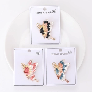 Macro detail of three colorful enamel butterfly brooches with rhinestones on cards