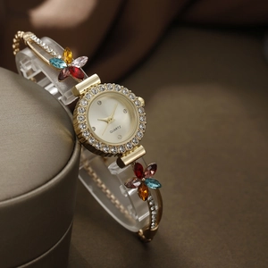 Elegant gold quartz bracelet watch with floral gemstones and sparkling rhinestone bezel