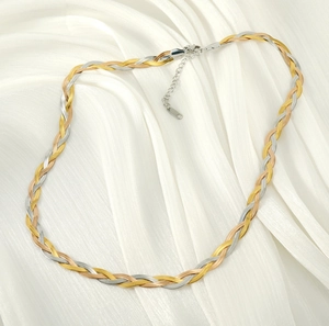 Macro detail of tricolor braided herringbone chain necklace in gold, silver and rose gold