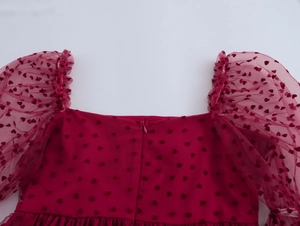 Détails du col carré et manches bouffantes en tulle avec flocage de cœurs sur robe bordeaux