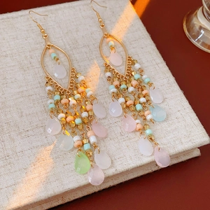 Close-up of Bohemian drop tassel earrings with colorful acrylic beads and golden hooks