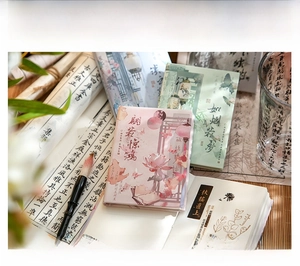 Close-up of A7 notebooks with traditional Chinese landscape and floral illustrations