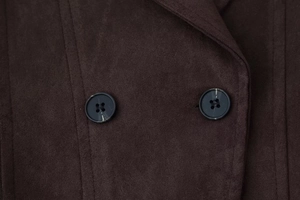 Détail du tissu en daim marron avec deux boutons noirs circulaires parallèles