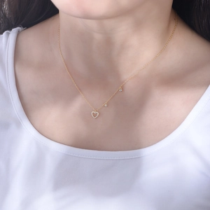 Detailed view of an S925 silver heart necklace with zircons on a female model neck