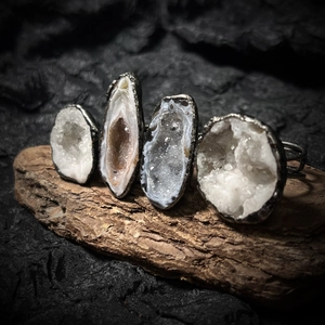 Vintage handmade geode crystal rings with silver-plated adjustable bands on wood