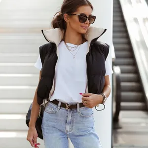 Detail of a black stand-collar vest paired with a white tee and blue jeans outfit
