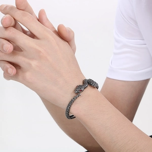 Close-up of vintage snake cuff bracelet with red rhinestone eyes on man's wrist