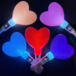 Detailed macro of heart-shaped glow sticks with glitter finish and vibrant LED lights