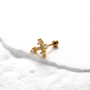 Detail of a gold-plated cross stud earring with light blue and white cubic zirconia