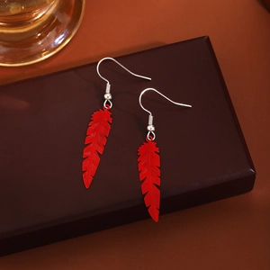Bohemian red feather dangle earrings with metallic hooks on dark jewelry box
