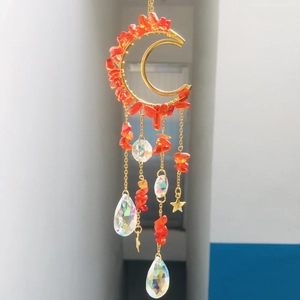 Detail of moon suncatcher with red beads, golden stars, and teardrop crystals
