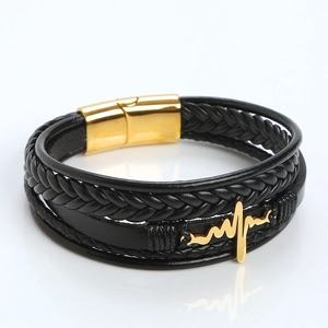 Detail of leather bracelet featuring gold heartbeat charm and magnetic clasp closure