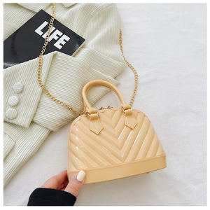 Close-up of a cream shell-shaped jelly bag with gold chain strap on a white background