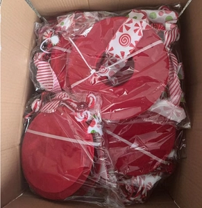 Detailed view of bulk packed red candy-striped Christmas tree toppers in warehouse