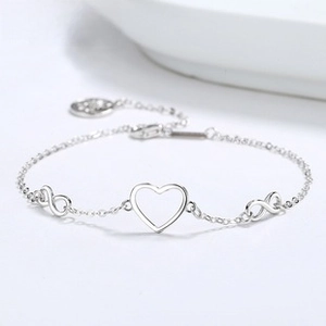 Close-up of 925 sterling silver bracelet featuring infinity and hollow heart charms