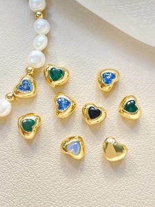 Close-up of heart charms with 14k gold plating and zirconia inlay for DIY jewelry