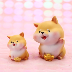 Detailed view of two cute golden Shiba Inu figurines with fortune ingots for car decor