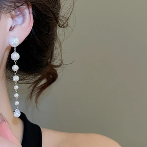 Close-up of long tassel pearl earrings with zircon waterdrop pendant on model