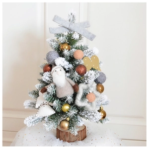 Close-up of mini Christmas tree with cedar wood base, felt stars, and grey bow decorations