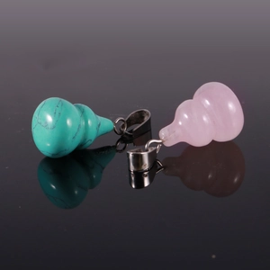 Close-up of turquoise and rose quartz gourd pendants with metal rings and reflections