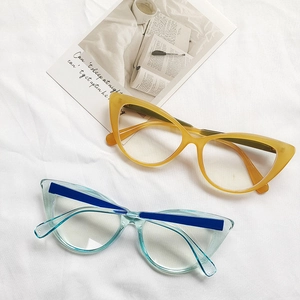 Detail of amber and transparent blue cat-eye glasses frames on white fabric