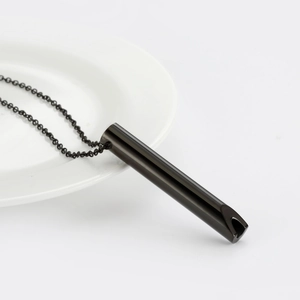 Vue détaillée du pendentif sifflet de méditation noir sur une assiette en céramique