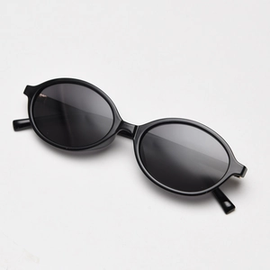 Close-up of black oval polarized sunglasses with durable plastic frame on a white surface