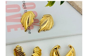 Detailed close-up of 18K gold-plated stainless steel stud earrings with feather and spiral texture