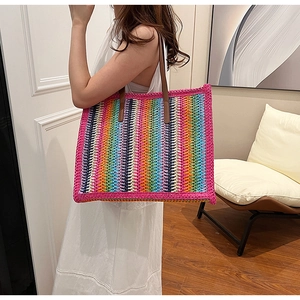 Detailed view of rainbow striped woven tote bag with premium brown leather handles