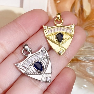 Macro shot of shield-shaped pendant with blue droplet gemstone and cubic zirconia inlay