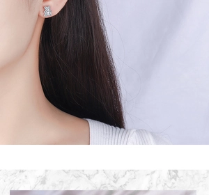 Close-up of a sparkling bear-shaped stud earring with white crystals on ear