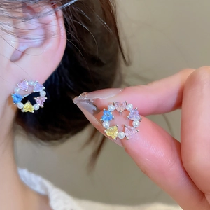 Detail of wreath earrings with colorful heart-shaped zircons and white pearls