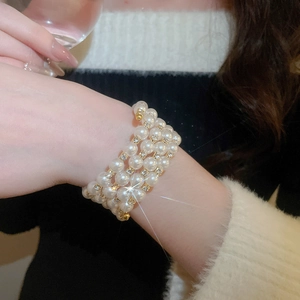 Close-up of multilayer pearl bracelet with gold accents and sparkling rhinestones on wrist