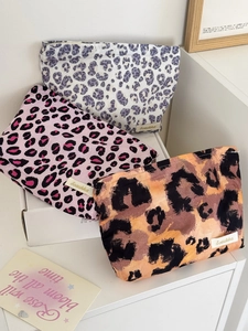 Detailed view of three leopard print canvas pouches in purple, pink and classic tan colors
