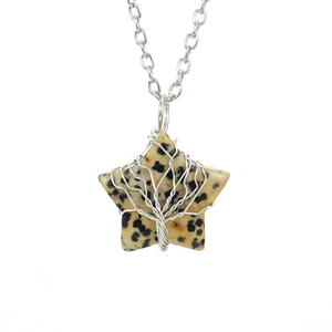 Macro detail of spotted natural stone star pendant with silver tree of life wire wrap