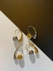 Detailed view of French vintage teardrop earrings with gold and silver metal spheres