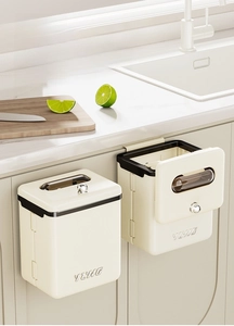Detail of cream wall-mounted kitchen bin showing dual-opening lid and hanging mechanism