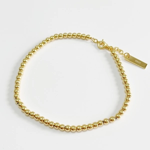 Minimalist 925 sterling silver golden bead bracelet with adjustable chain on white background