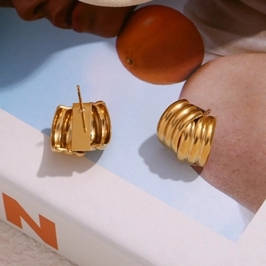 Detail showing high-polish 18K gold-plated stainless steel earrings with triple layer ridges