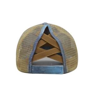 Detail view of washed denim ponytail baseball cap with elastic criss-cross back and velcro strap