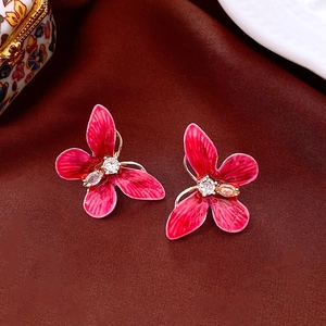 Vue détaillée de la boucle d'oreille fleur rose avec dorure et zircon au centre